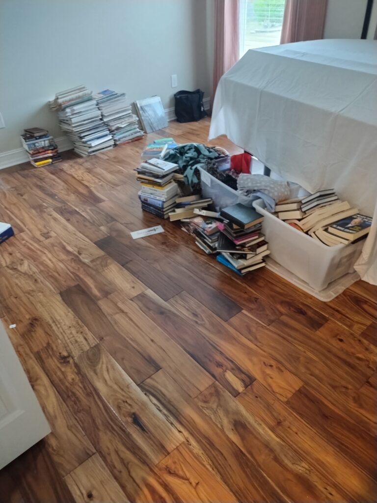 Cluttered bedroom with piles of books and junk on bed during hoarder cleanout in Citrus Hills Florida
