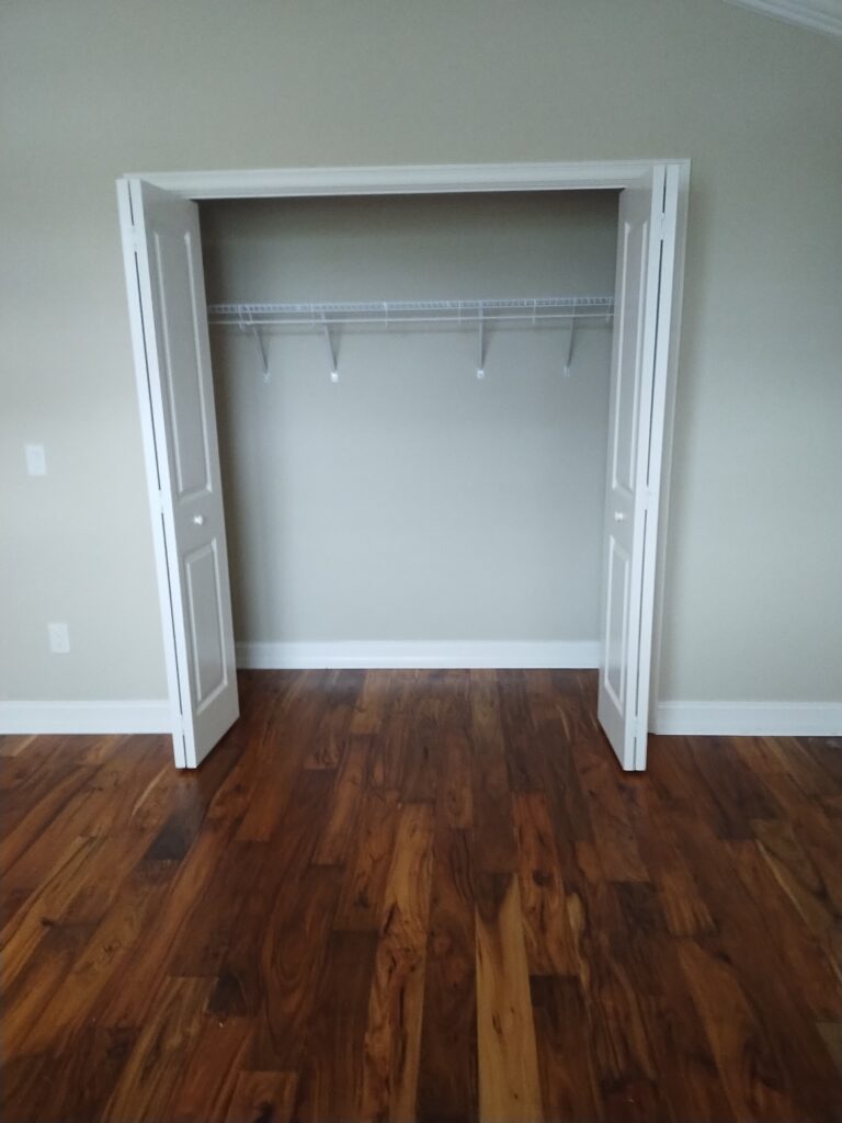 Vacant bright bedroom with organized open closet and no clutter ready for occupancy in Central Florida home